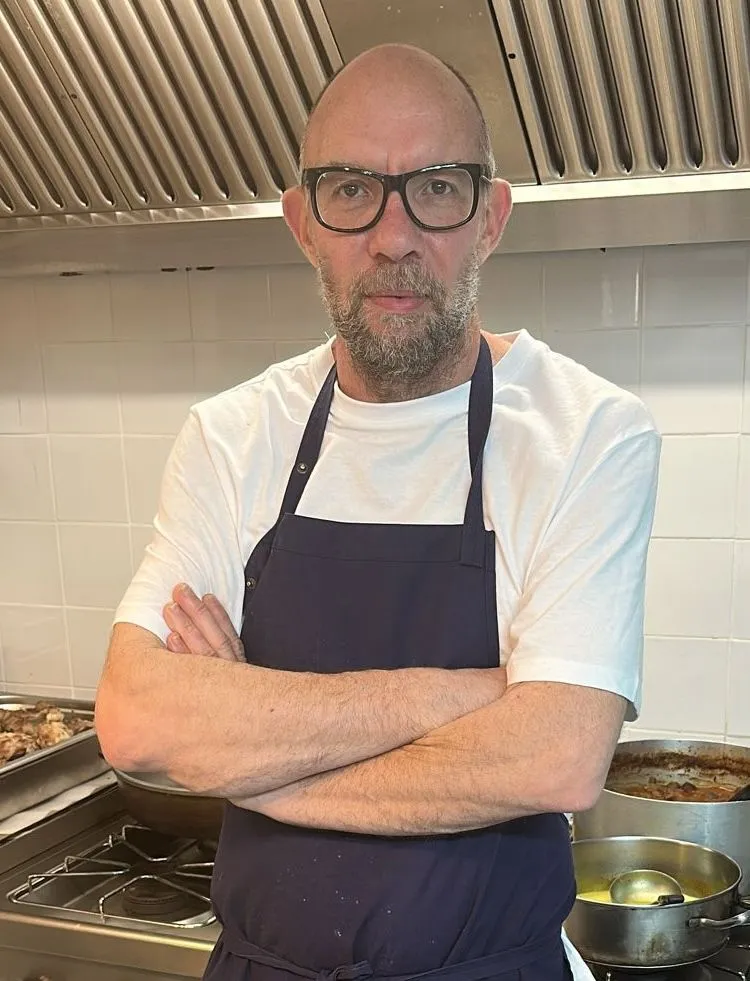 Emmanuel Thomas, chef at Le Bistrot, standing in the kitchen with folded arms